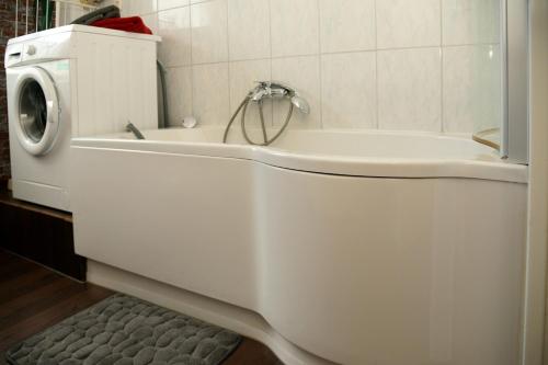 La salle de bains est pourvue d'une baignoire blanche et d'un lave-linge. dans l'établissement Vintagetraum, à Gevelsberg