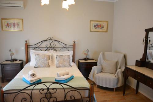 - une chambre avec un lit et une chaise dans l'établissement Villa Alkmini, à Agnítsini
