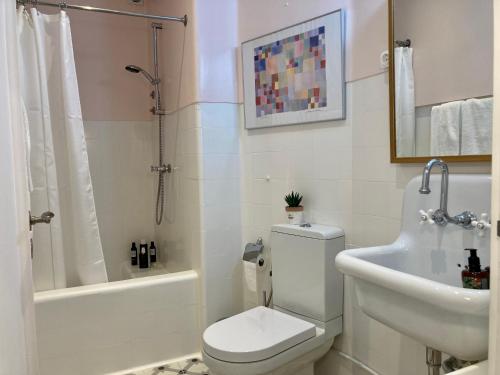 a bathroom with a toilet and a sink and a shower at Quiet Studio with garden 8 Min from Beach in Estoril