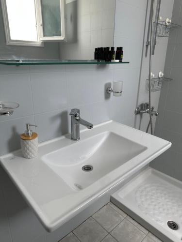 a white sink in a bathroom with a mirror at Kleanthi Apartments in Drios