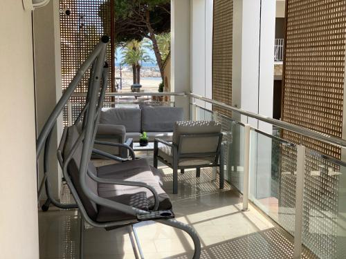 a balcony with chairs and tables on a building at SOLIMAR 10 SALOU Solo FAMILIAS con Parking y piscina in Salou