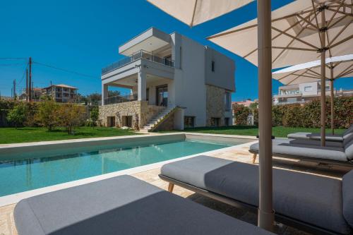 a villa with a swimming pool and a house at Sea Wind Luxury Villa with Private Heated Pool Kassandra Halkidiki in Nea Fokea