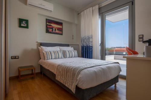 a bedroom with a bed and a large window at Sea Wind Luxury Villa with Private Heated Pool Kassandra Halkidiki in Nea Fokea