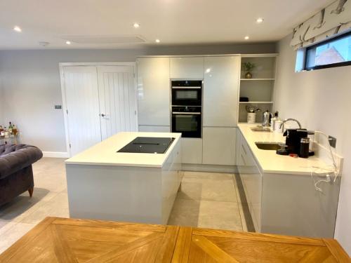 a kitchen with white cabinets and a counter top at Luxury 2 bed home in Stagsden