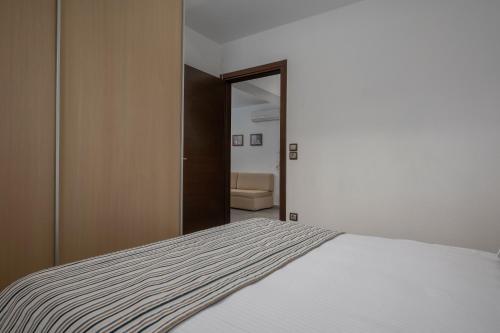 a bedroom with a white bed and a mirror at Sea Wind Luxury Villa with Private Heated Pool Kassandra Halkidiki in Nea Fokea