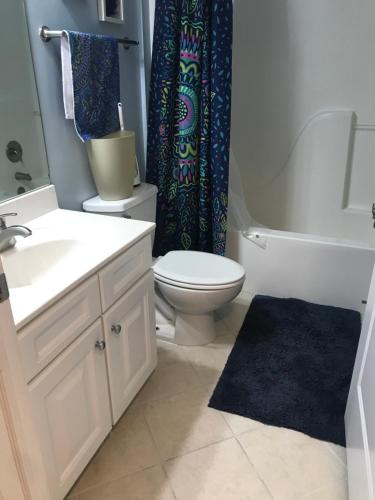 a bathroom with a toilet sink and a shower curtain at Beautiful Condo in Ocean City