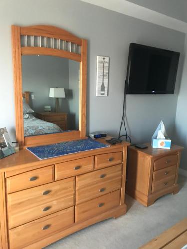 1 dormitorio con tocador de madera grande y espejo en Beautiful Condo en Ocean City