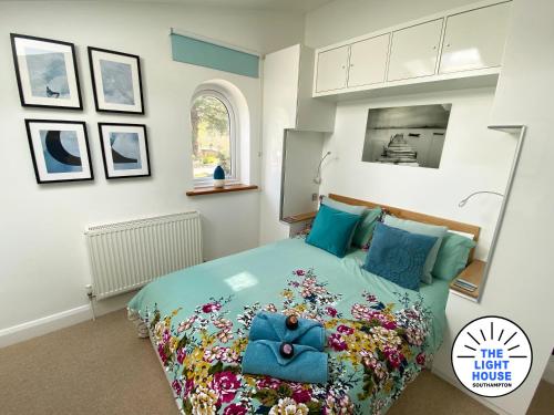 Un dormitorio con una cama con un bolso azul. en Welcome to The Light House a tranquil city retreat. en Southampton