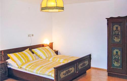 ラーデンタインにあるAwesome Home In Radenthein With 3 Bedroomsのベッドルーム1室(黄色とオレンジのストライプの枕付きのベッド1台付)