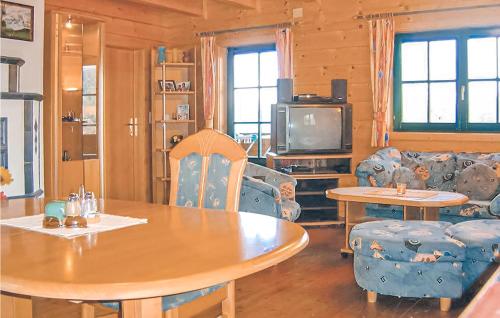 salon ze stołem, krzesłami i telewizorem w obiekcie Schoenes Ferienhaus w mieście Radenthein
