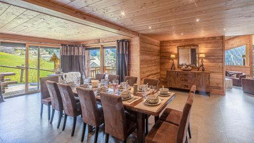 une salle à manger avec une longue table et des chaises dans l'établissement Savoyard - Chalet - BO Immobilier - Châtel Multipass 2025 Été offert par votre hôte pour 7 personnes, à Châtel