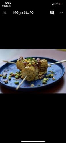 a plate of food with corn and peas on chopsticks at Apartahotel Plaza de ángel 74 in Barranquilla