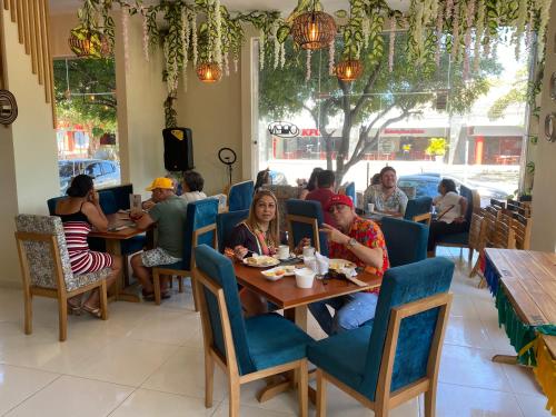Apartahotel Plaza de ángel 74 في بارانكويلا: مجموعة من الناس يجلسون على طاولة في مطعم