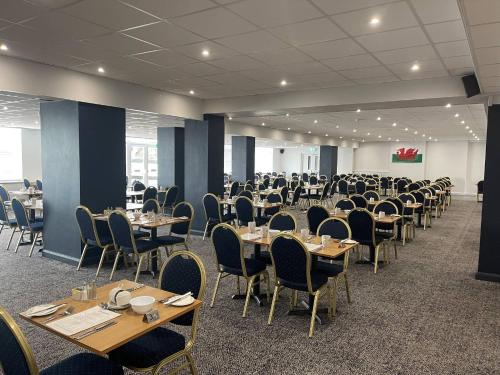 a dining room with tables and chairs and tablesearcher at Seabank Hotel in Porthcawl