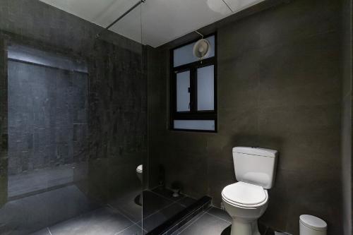 a bathroom with a toilet and a shower and a window at Les Barons in Hong Kong