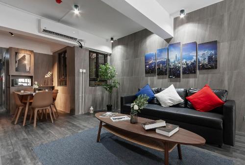 a living room with a black couch and a table at Les Barons in Hong Kong