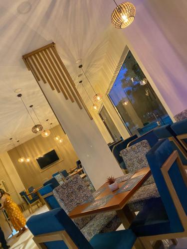 a restaurant with a wooden table and blue chairs at Apartahotel Plaza de ángel 74 in Barranquilla