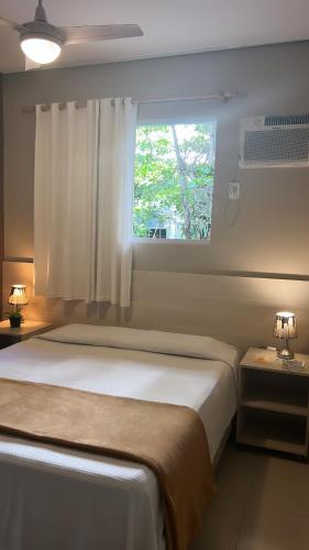 a bedroom with a large bed with a window at Hotel Rio in Guarujá
