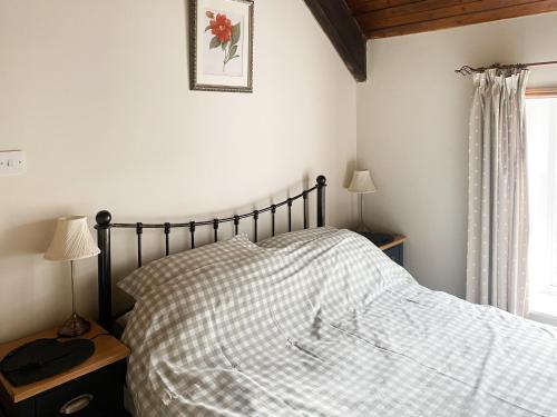 FryupにあるBeckside Cottageのベッドルーム1室(チェック入りの毛布、窓付)