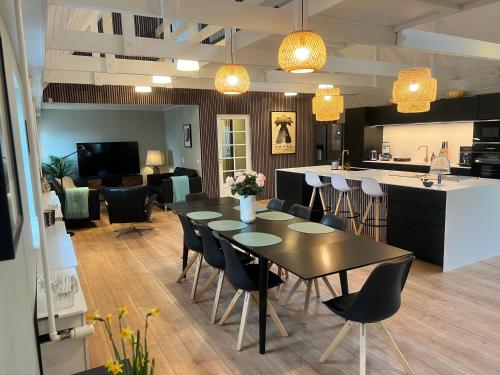 a room with a table and chairs and a kitchen at Større luksus Hus ved Assens in Assens