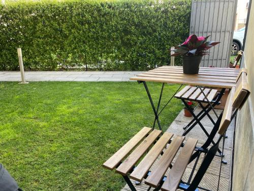 a wooden bench and a table and a potted plant at DaLu Florence apartment Davide - private car park 15 minutes to the city center in Florence