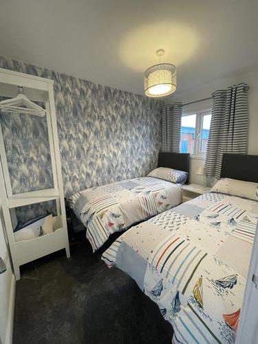 a bedroom with two beds and a window at Isla's Haven Holiday Chalet in Bridlington