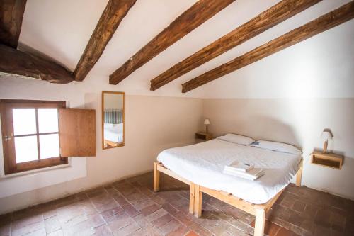 Schlafzimmer mit einem Bett in einem Zimmer mit Holzbalken in der Unterkunft Casa Rural Mas Garganta in La Pinya