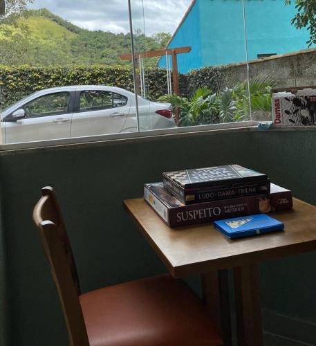 a pile of books sitting on a table with a car at Pousada Renovo da Serra in São Pedro da Serra