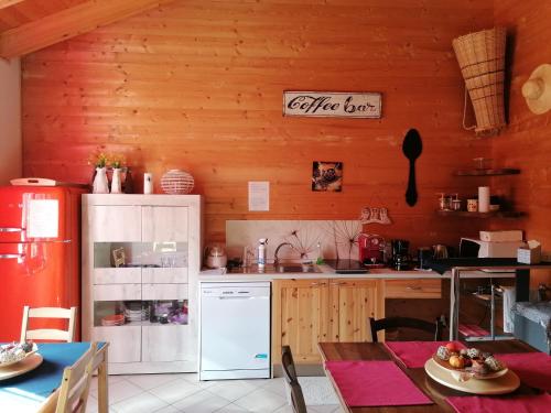 uma cozinha com um frigorífico branco e uma mesa em Agriturismo bio Apipoli em Lucino