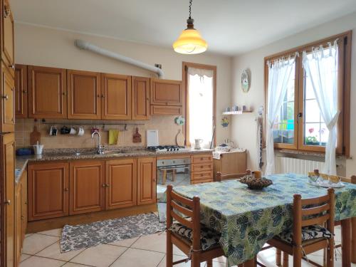 eine Küche mit Holzschränken und einem Tisch mit Stühlen in der Unterkunft Relax in collina a due passi dal mare in Torriana
