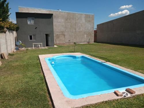 Cabaña piscina parque total privacidad Roldán في رولدان: مسبح ازرق كبير في ساحة بها مبنى