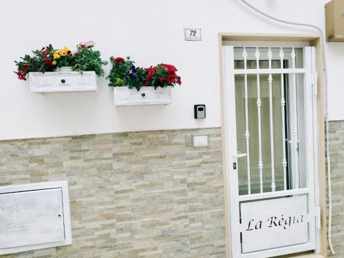 eine Tür mit zwei Blumenkästen an der Seite eines Gebäudes in der Unterkunft La Règia in Palagianello