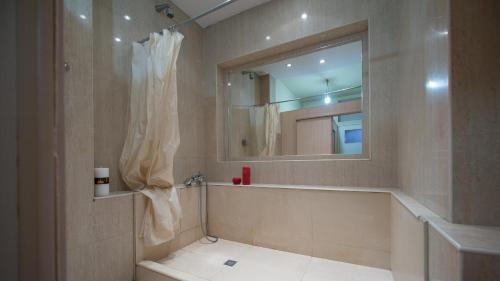 y baño con bañera, lavabo y espejo. en Lviv Euro Hostel, en Leópolis