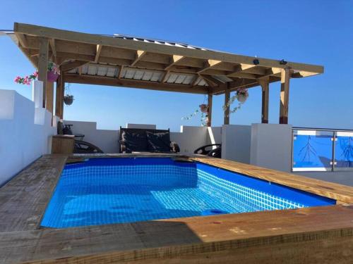 a swimming pool on the roof of a house at Tropical Inn Spacious 1 bed Apartment stunning rooftop terrace in San Felipe de Puerto Plata