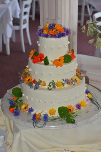 a white wedding cake with flowers on a table at The Brandon Inn in Brandon
