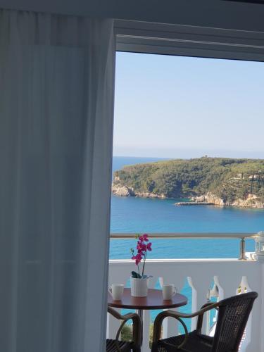 a table with chairs and a view of the ocean at Valtos View in Parga