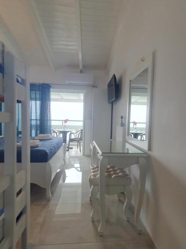 a bedroom with a bed and a table with a mirror at Valtos View in Parga