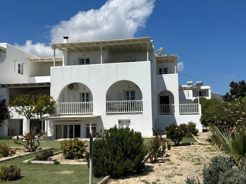 a white building with trees in front of it at Kleanthi Apartments in Drios