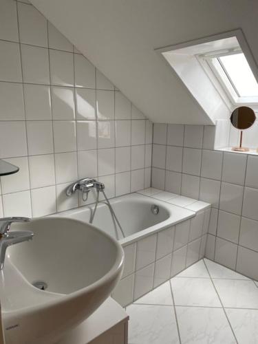 a white bathroom with a tub and a sink at Ferienwohnung Neetze in Neetze