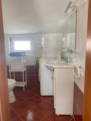 een badkamer met een wastafel en een toilet bij Sunny Apartment in Srima