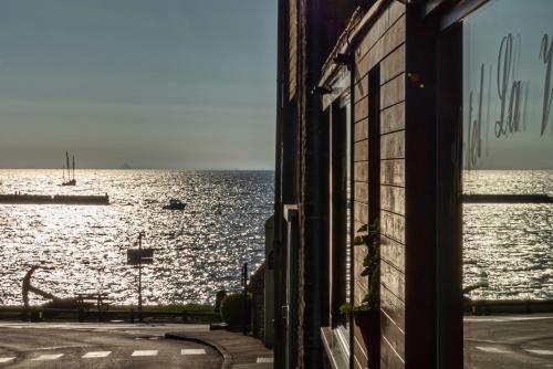 a window of a building looking out at the water at Hotel La Voilerie Cancale bord de mer in Cancale