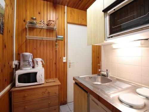 une cuisine avec un évier et un micro-ondes sur un comptoir dans l'établissement Studio 4 personnes hyper centre Mont-Dore avec balcon et wifi - FR-1-608-69, à Le Mont-Dore
