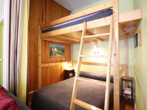 Ce lit superposé se trouve dans un dortoir avec une échelle. dans l'établissement Studio 4 personnes hyper centre Mont-Dore avec balcon et wifi - FR-1-608-69, à Le Mont-Dore