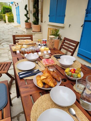 a wooden table with plates of food on it at La Maison des Eaux in Saint-Jean-de-Thurac