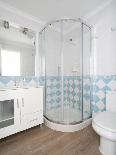 a bathroom with a shower with a toilet and a sink at HOUSE IN PRIVATE URBANIZATION in Beniarbeig