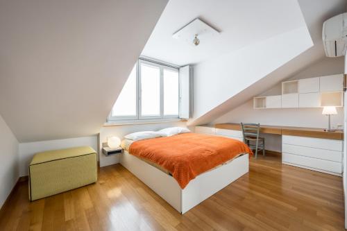 米兰tHE Orange Attic - Navigli Area的一间卧室，配有一张床、一张书桌和一扇窗户