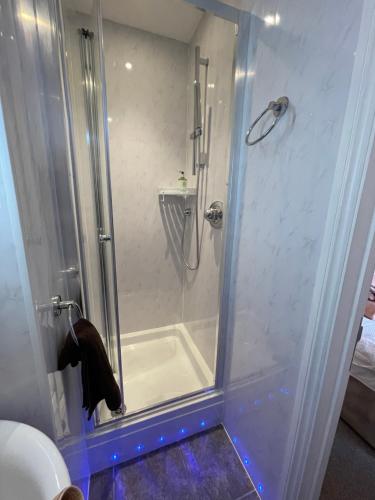 a shower with a glass door in a bathroom at Rivendell Guest House in Swanage