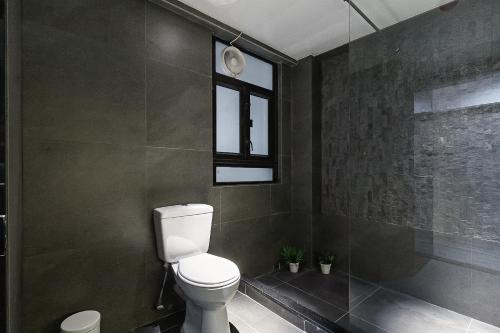 a bathroom with a toilet and a shower and a window at Les Barons in Hong Kong