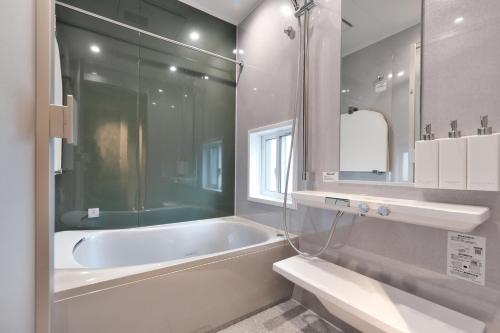 a bathroom with a bath tub and a sink at SHIN kyoto in Kyoto