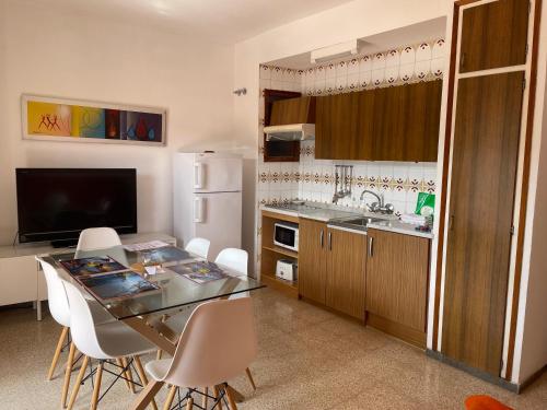 eine Küche mit einem Tisch und eine Küche mit einem Kühlschrank in der Unterkunft Apartamentos El Sol in Tossa de Mar